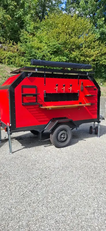 La façade du bar en plein jour : trois becs de tireuse en laiton et comptoir en bois déplié